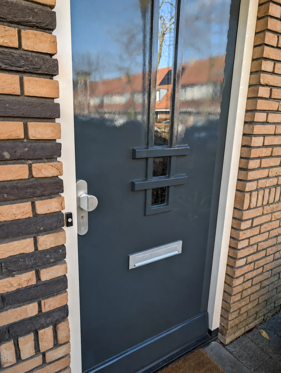 Strak geschilderde donkergrijze voordeur